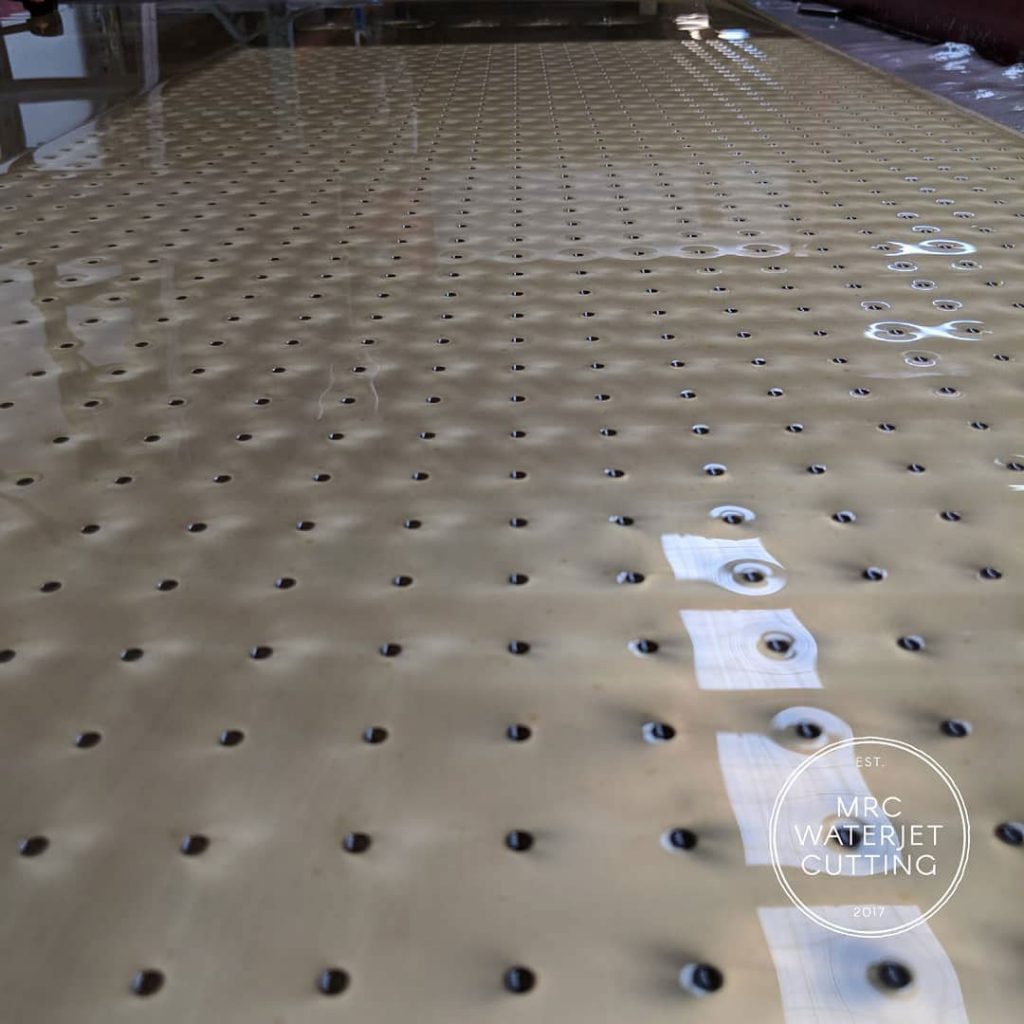 waterjet cut brass in a perforated pattern